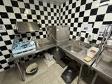 a kitchen with a checkered wall and stainless steel counter tops