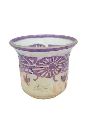 un vase violet et blanc orné de fleurs, posé sur une surface blanche