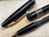 three pens sitting on top of a table next to each other