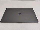 a black apple laptop sitting on a white surface