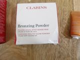 a box of clarins next to a tube of sunscreen