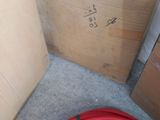 a red hose sitting on the floor next to a cardboard box