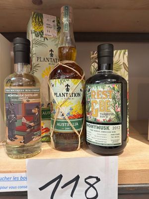 des bouteilles d'alcool sur une étagère dans un magasin, avec une étiquette de prix