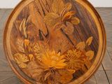 a wooden plate with flowers on it sitting on a tiled floor