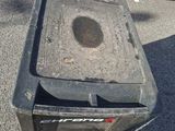 a trash can sitting in the middle of a parking lot