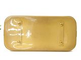 yellow plastic purse with gold hardware on top of it next to a potted plant