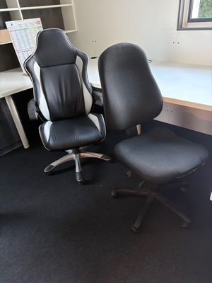 une chaise de bureau noire assise devant un bureau d'ordinateur