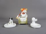 trois figurines représentant un chien et un chien assis sur une chaise