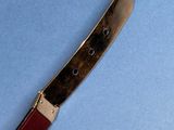 a close up of a knife with a red handle on a blue surface