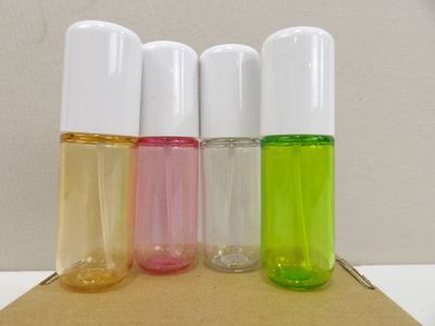 four different colored bottles of perfume sitting on top of a cardboard box