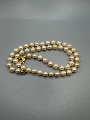a white pearl necklace with a gold clasp