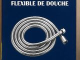 La boîte contenant le tuyau de douche flexible est ouverte et prête à l'emploi.