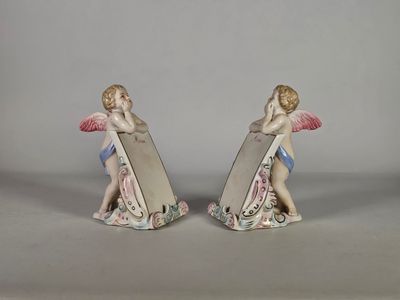 paire de figurines représentant deux chérubins ailés et un miroir