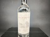 une vieille bouteille de vin posée sur une table noire