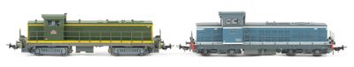 two toy trains sitting side by side on a white surface
