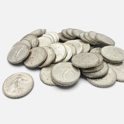 une pile de pièces d'argent sur une surface blanche