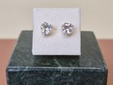 a pair of earrings sitting on top of a marble block