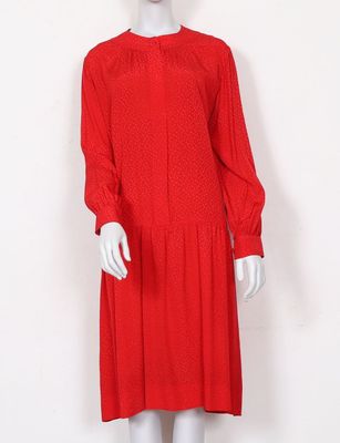a mannequin wearing a red dress with long sleeves