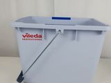 a close up of a plastic bucket with a handle on a table