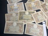 several old french currency notes are on a black surface