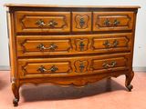 une commode en bois surmontée de nombreux tiroirs