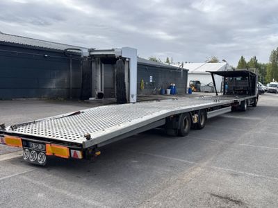 the flatbed trailer is parked in a parking lot in front of a building