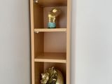 a tall wooden shelf with a glass vase on it