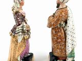 two figurines of women dressed in traditional clothing standing next to each other