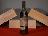 une bouteille de vin posée sur une table, à côté de deux caisses en bois