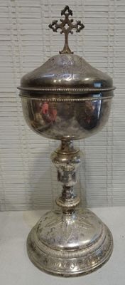 a silver bowl with a cross on it on a table