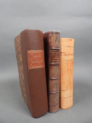 three books sitting on top of each other on a gray surface