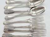 five spoons and six forks sitting on a table