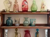 many different colored vases on a shelf in a room