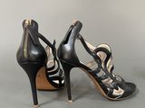 a pair of black high heels with zippers on the toes