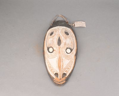 un masque accroché au mur avec une étiquette