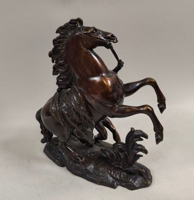 bronze statue of a horse on its hind legs on a white background