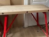 une table en bois aux pieds rouges dans une pièce