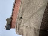 a zipper on the inside of a tan jacket