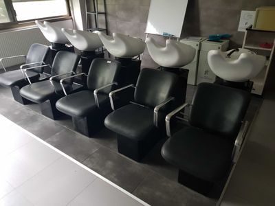 a row of chairs with sinks in the middle of the room