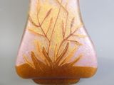 un vase en verre orné d'une plante, posé sur une table