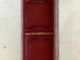 un vieux livre sur lequel on a écrit quelque chose, posé à côté d'une feuille de papier