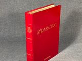 the red book is sitting on a gray surface with a gray background