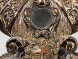 a close up of a silver vase with a face on it