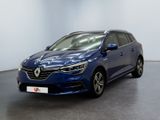 Une voiture bleue est garée dans une pièce aux murs blancs.