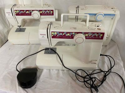 four sewing machines sitting on a table with a mouse on it