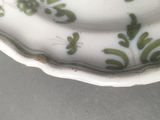 a white plate with green leaves on it on a table