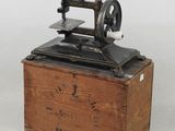 une vieille machine à coudre posée sur une caisse en bois