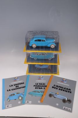 trois petites voitures bleues sont empilées les unes sur les autres dans une vitrine
