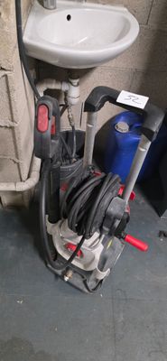 un lavabo blanc et un tuyau noir et rouge dans une pièce