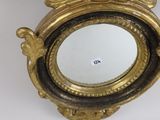 a gold clock with an eagle on it and a mirror in front of it